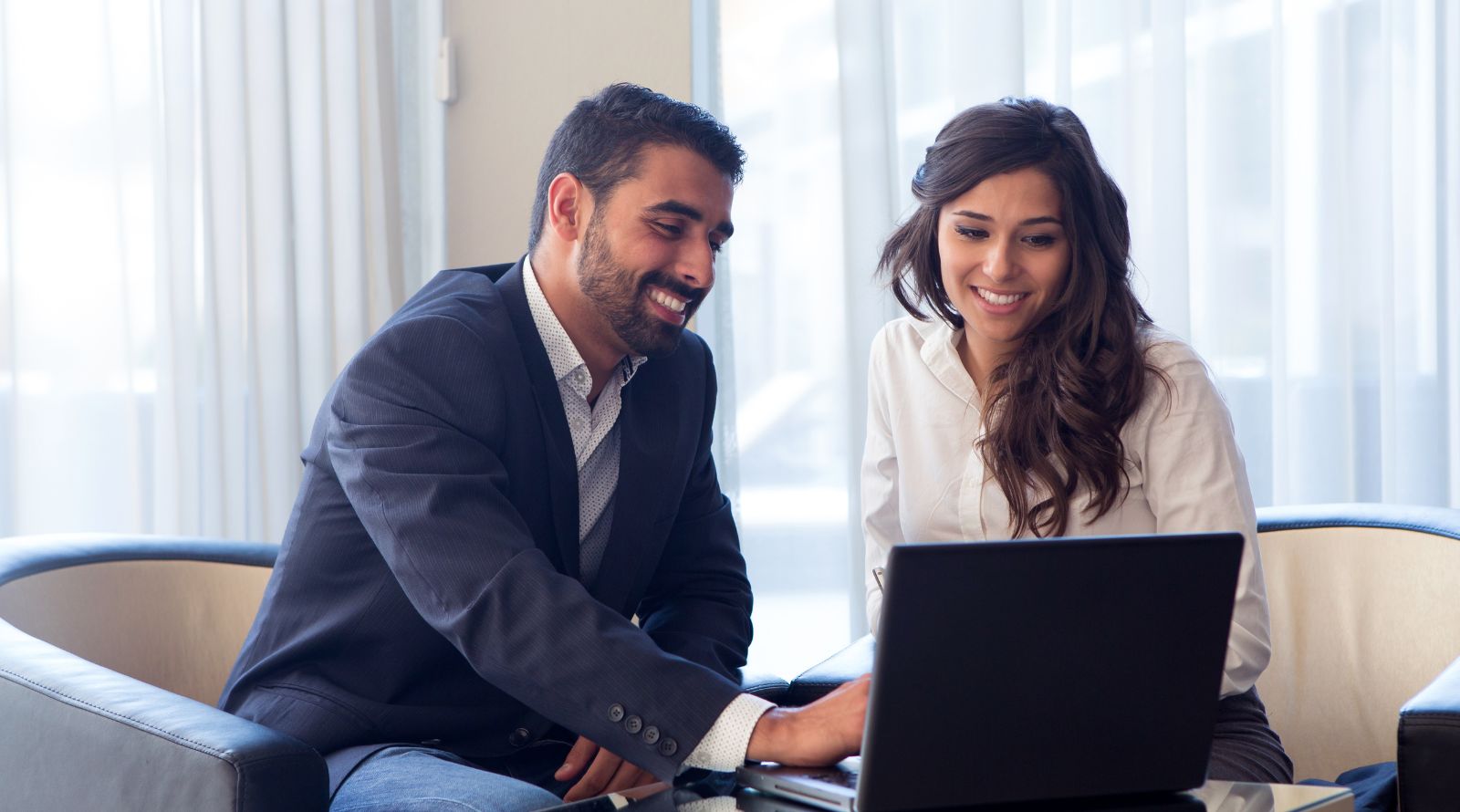 Man and women in chairs on laptop