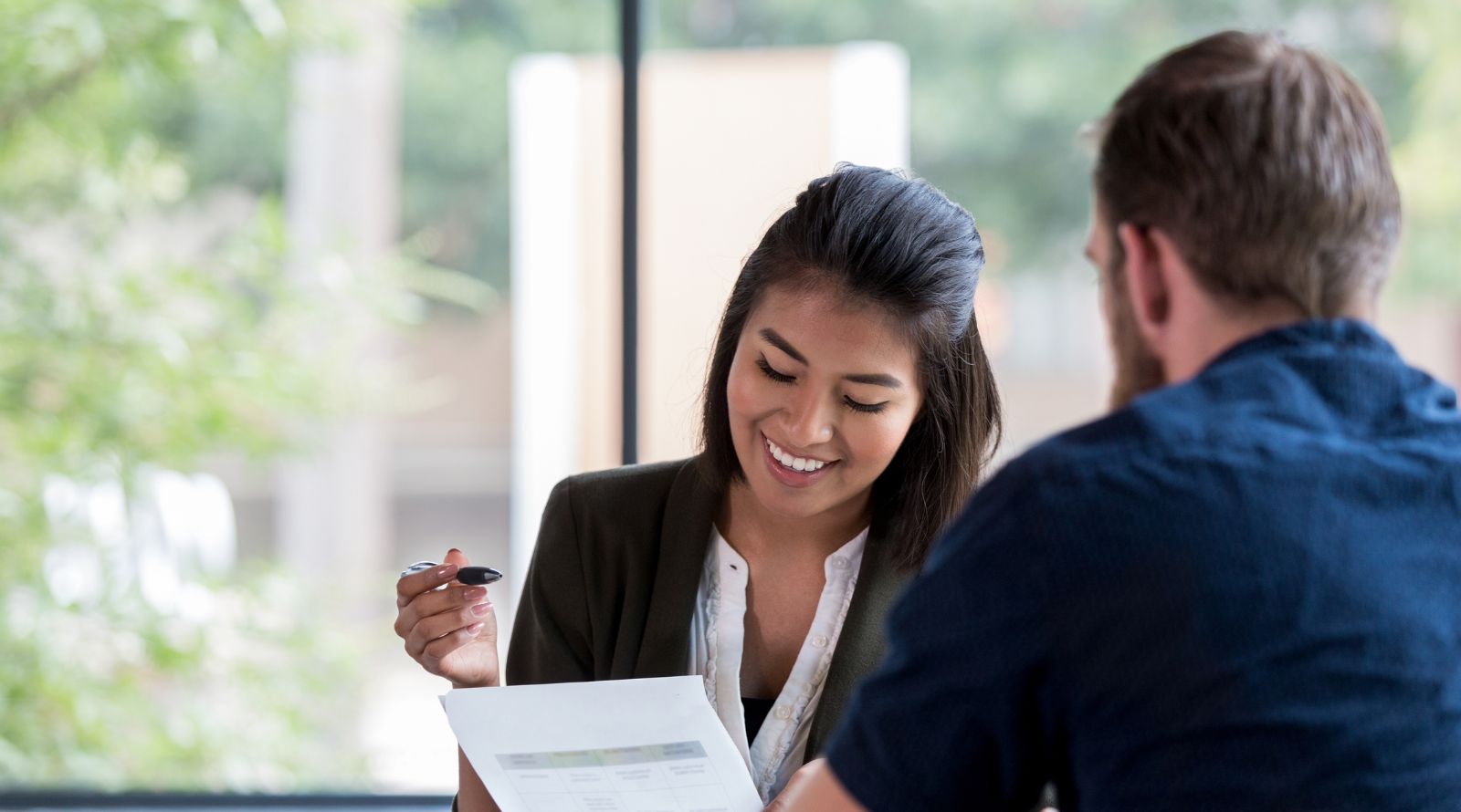 girl with paper in hand and male talking